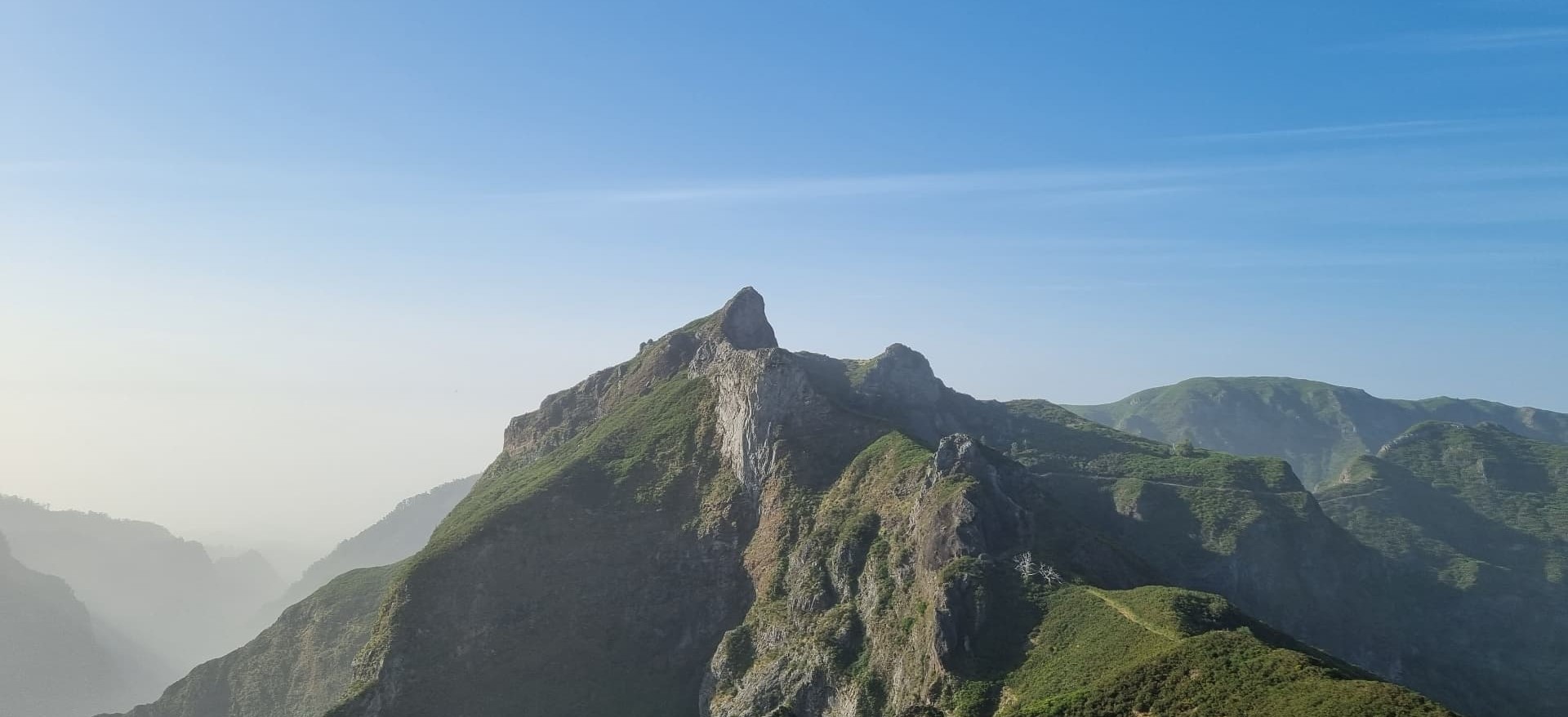 Skalnatý vrchol a zelený hřeben na Madeiře v mlžném údolí