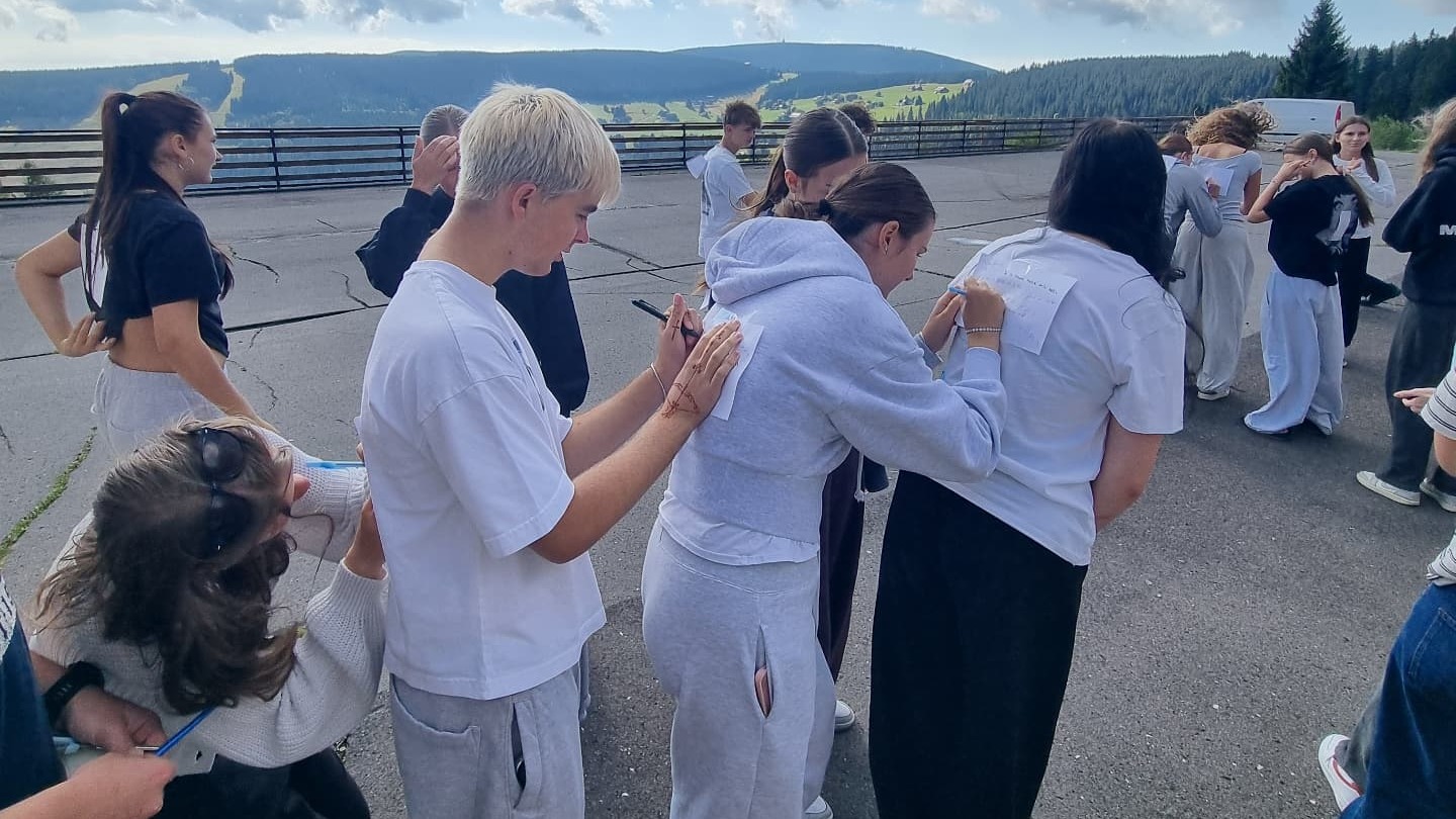 Studenti si píší vzkazy na záda na horské vyhlídce